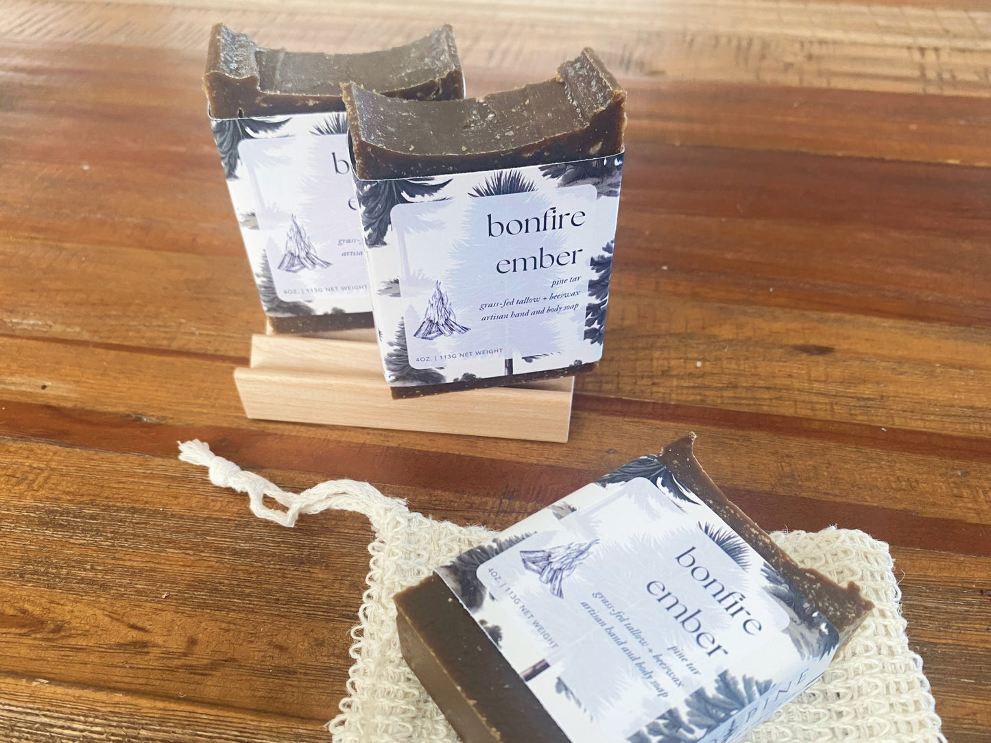 three bars of bonfire ember soap on a wooden table.