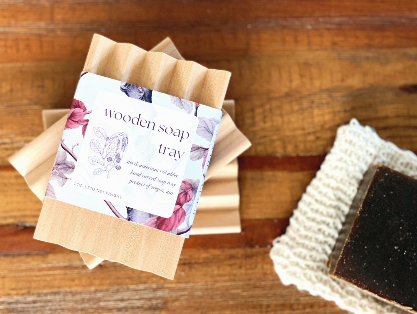 stack of wooden soap trays laying next to a pine tar soap on a wooden table