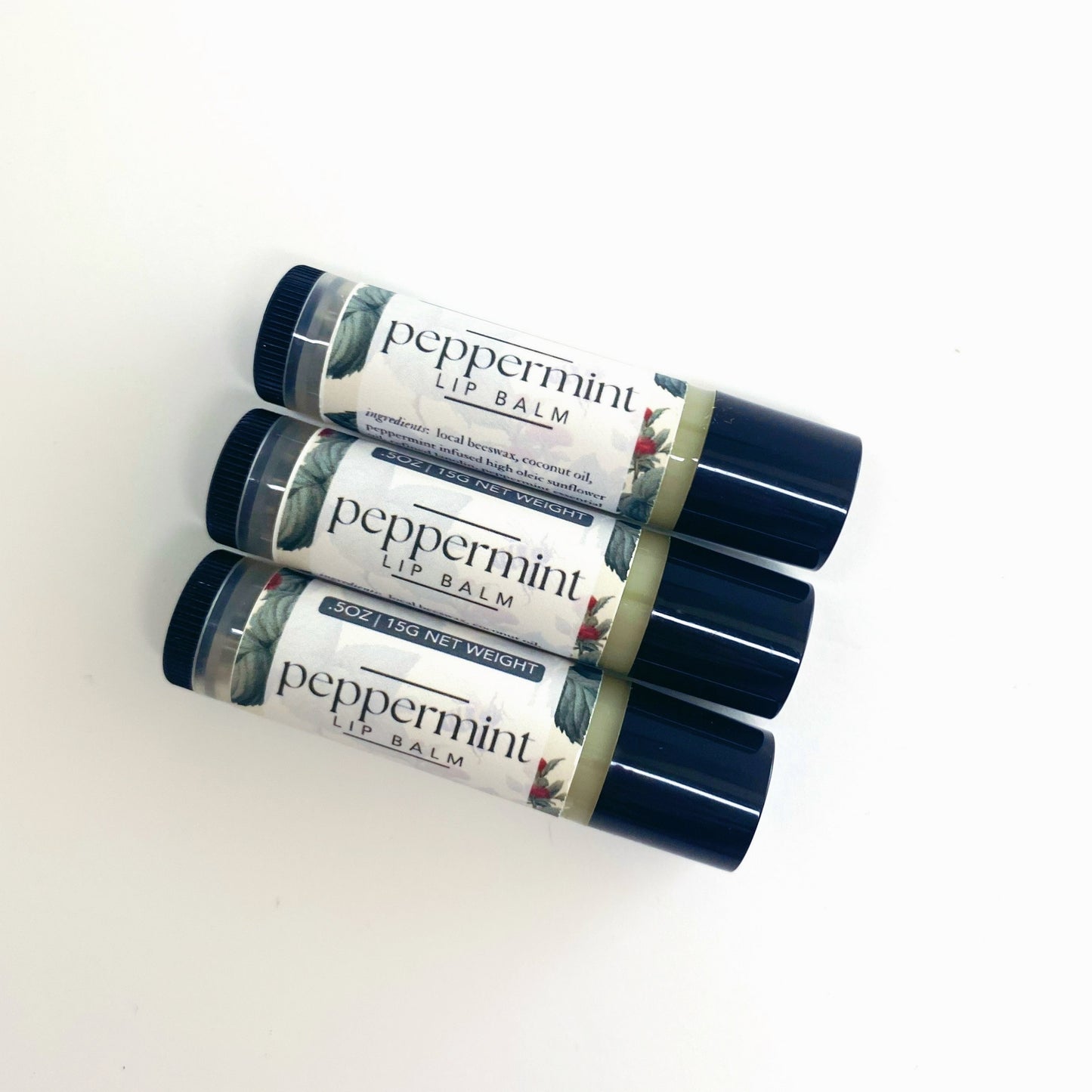 three peppermint lip balm tubes laying on a white backdrop