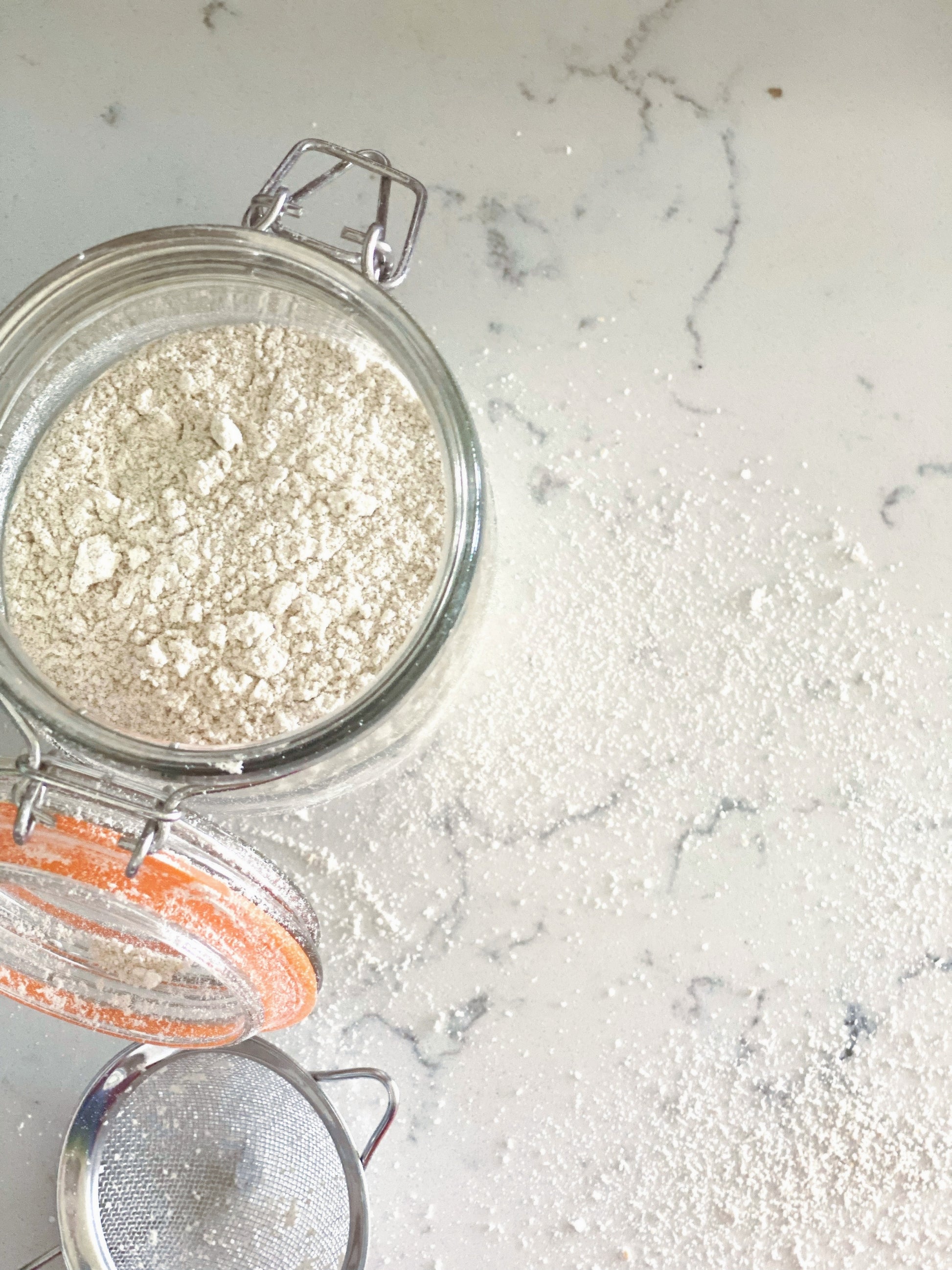 opened jar of colloidal oatmeal on a quartz countertop