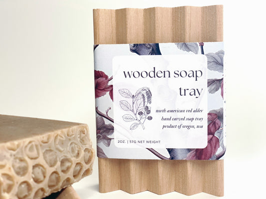 wooden soap tray against a white backdrop with spiced honey soap bar next to it.